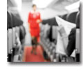 Photo of inside of an airplane with seats and cabin crew in background