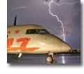 Photo of Air Canada Jazz Bombardier Dash 8 parked at a Montreal Airport during a nighttime thunderstorm