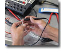Photo of an aircraft technician using a multimeter probe during the construction of a hydraulic activator