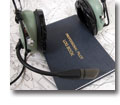 Photo of a pilot's head set, log book and navigational chart