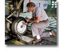 Photo of an aircraft technician checking the tire pressure of the nose gear on a Boeing 737