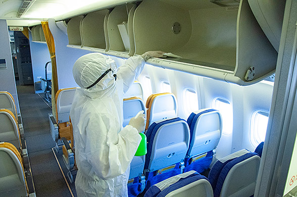 Photo of worker disinfecting an airplane cabin